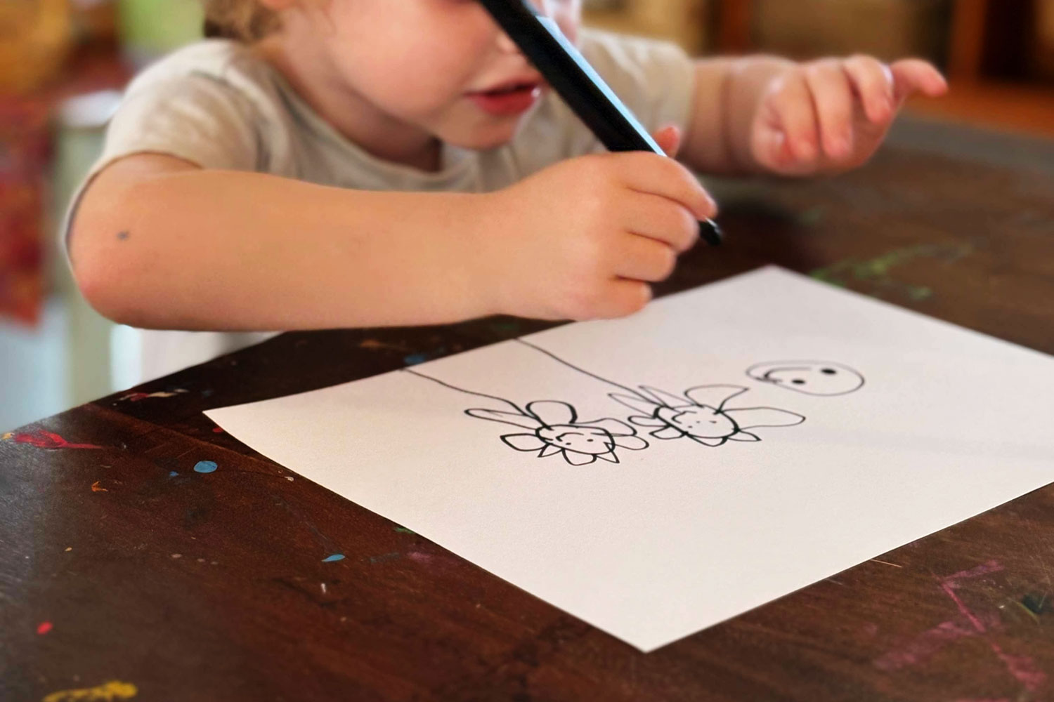 A photograph of chalk drawings on a rough red surface. The main character appears to be a childlike rendition of SpongeBob Squarepants and beside him is a snail